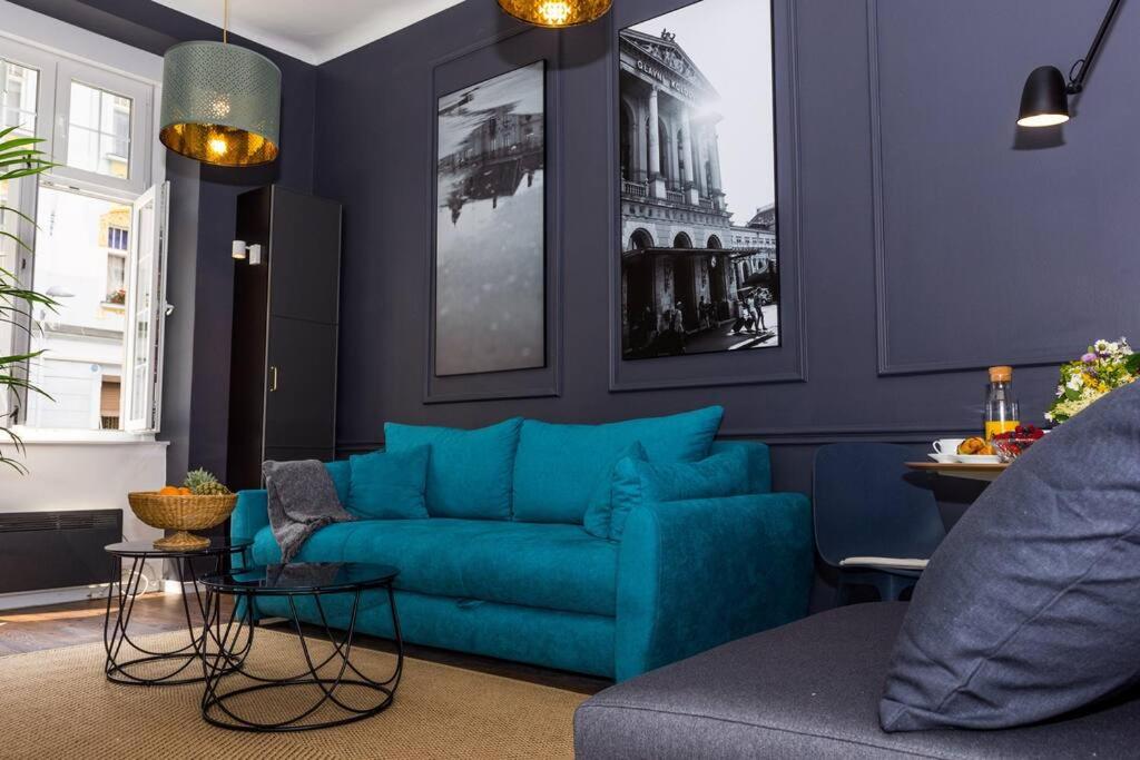 um sofá azul numa sala de estar com paredes azuis em Studio Apartment Lubynski in center of Zagreb em Zagreb