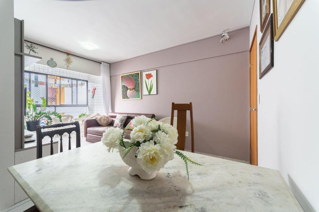 un vase de fleurs sur une table dans le salon dans l'établissement Apt 2 quartos com varanda próximo Praça Casa Forte o bairro mais agradável do Recife ARN901, à Récife