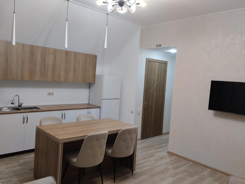 una cucina con tavolo, sedie e televisione di Guest house number 1 a Batumi