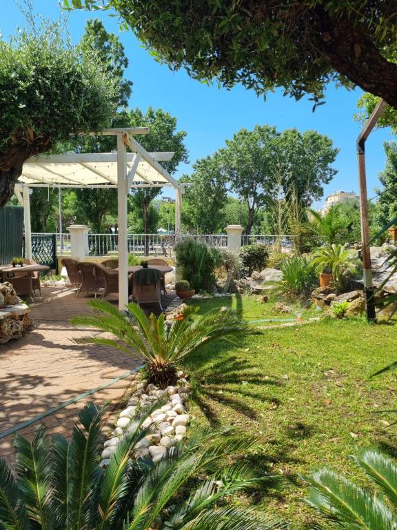 un jardín con pérgola y mesa de picnic en My Room Roma, en Lido di Ostia