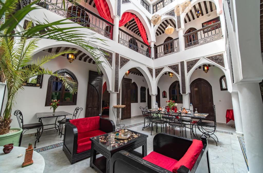une cour avec des tables et des chaises dans un bâtiment dans l'établissement Riad Balkisse, à Marrakech