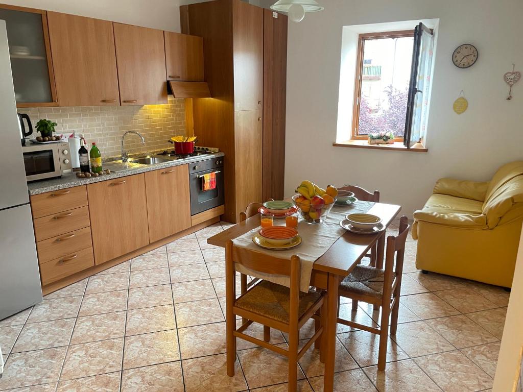 uma cozinha com uma mesa e cadeiras e uma cozinha com uma mesa e uma cozinha em Appartamenti Allegrini Tuenno em Tuenno