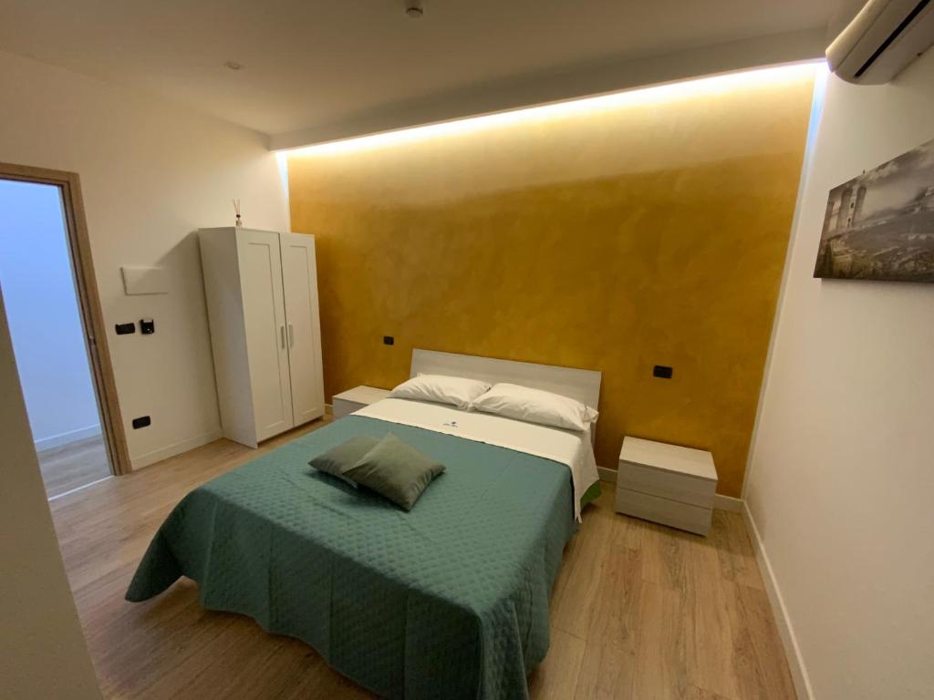 um quarto com uma cama com um cobertor verde em B&B Gisa House em Pomigliano dʼArco