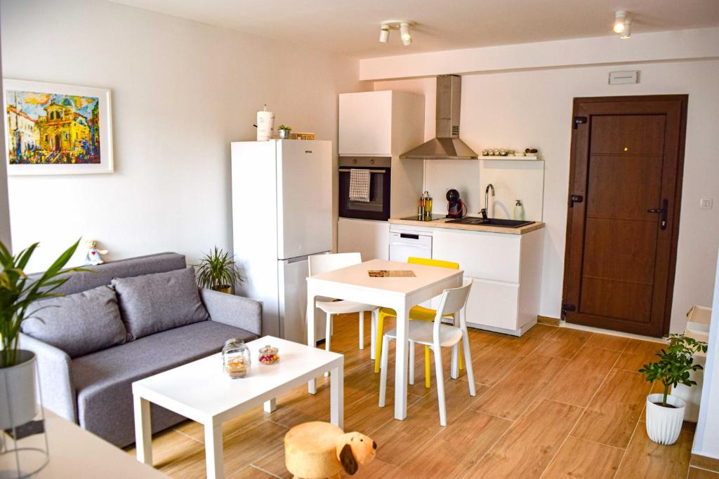 sala de estar con sofá, mesa y cocina en Studio Apartments Anija, en Dubrovnik