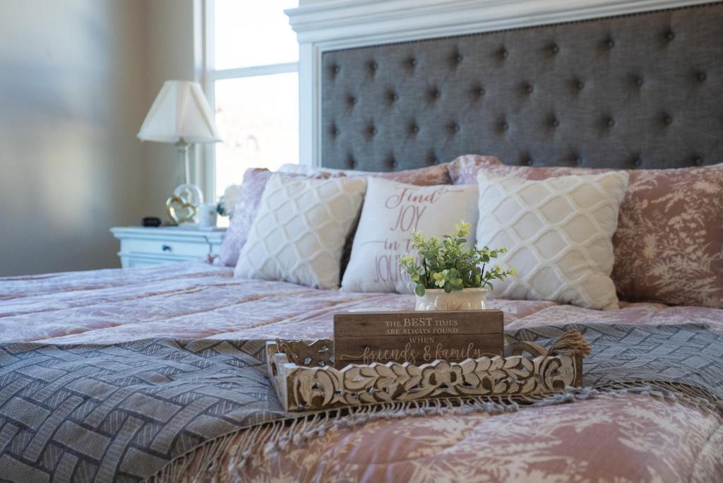 a bed with a pink comforter and a sign on it at New South Zion Coral Cliffs - 4 bed, 3 bath, hot tub, deck in Hildale
