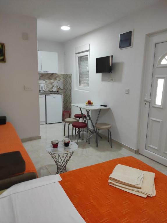 a room with a bed and a table with chairs at Apartmani CECA 012 Sutomore in Sutomore