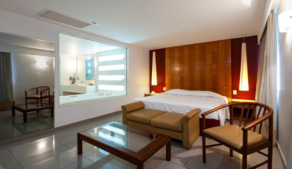 um quarto com uma cama, uma cadeira e uma mesa em Hotel Atlântico Copacabana no Rio de Janeiro