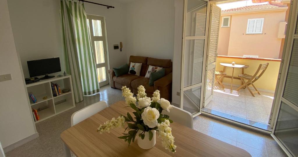 ein Wohnzimmer mit einem Tisch mit Blumen darauf in der Unterkunft Casa Lucia in Cala Gonone