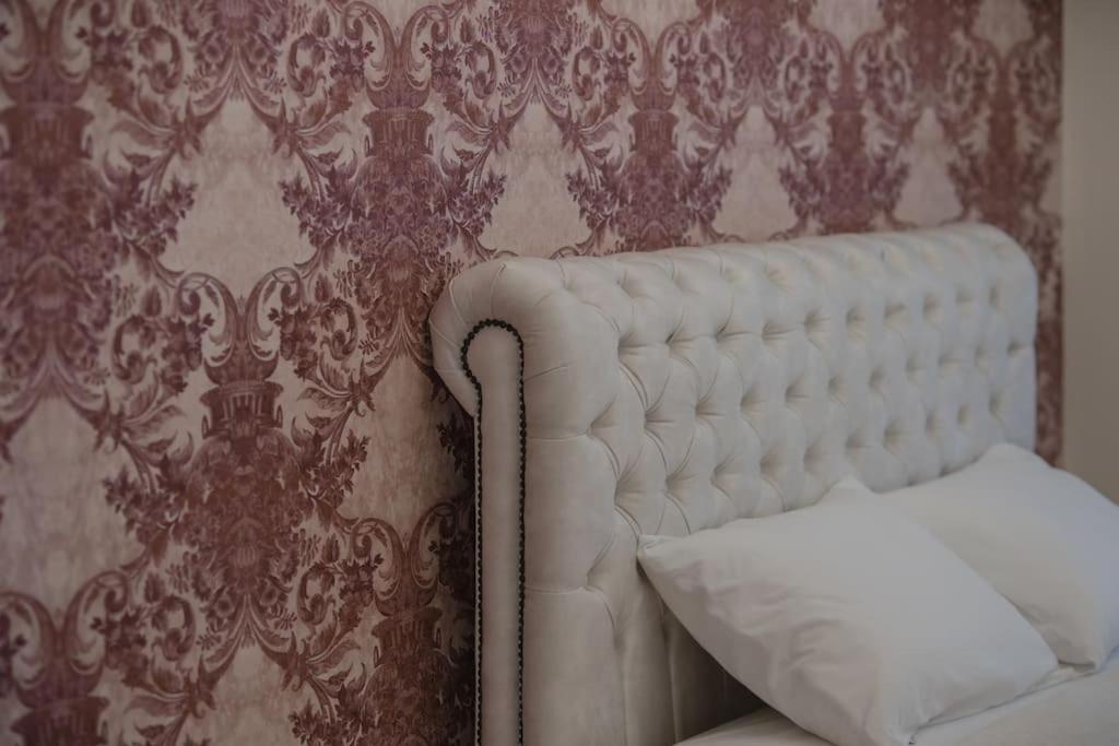 a white couch in front of a wall with wallpaper at Mulberry tree villa in Agios Nikolaos
