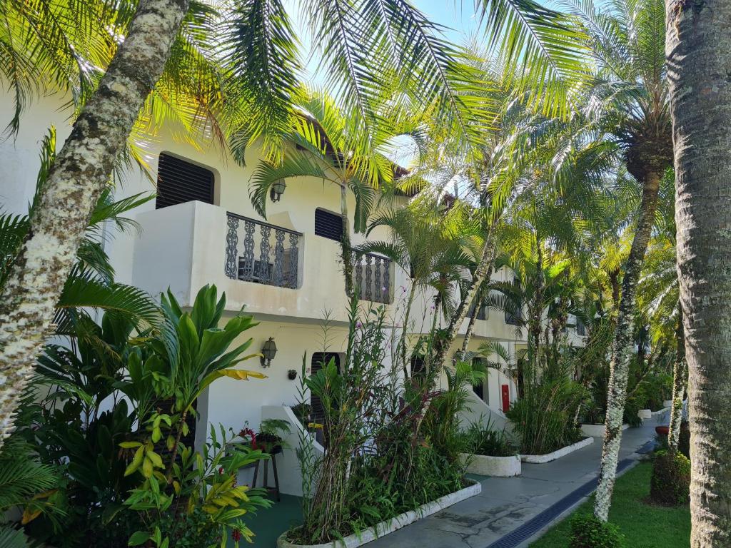 ein Gebäude mit Palmen davor in der Unterkunft Apartamento - Cond. Winbledon - Praia Toninhas in Ubatuba