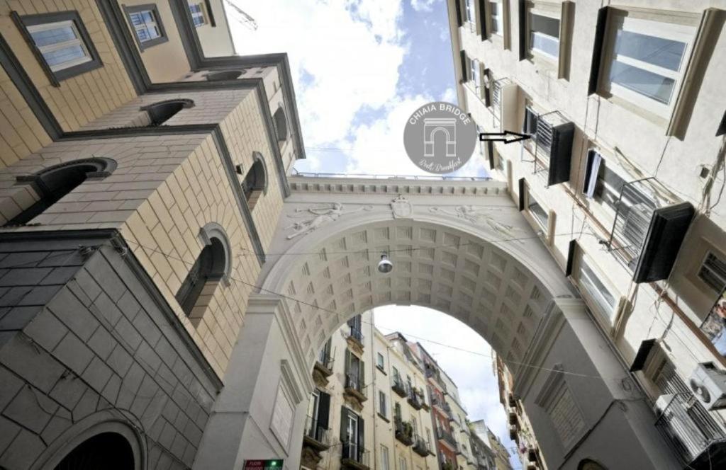 an archway in the middle of a city with buildings at Chiaia Bridge B&B in Naples