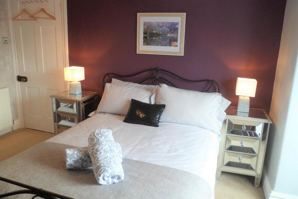 a bedroom with a white bed with two night stands at The Swainson Suite in Windermere
