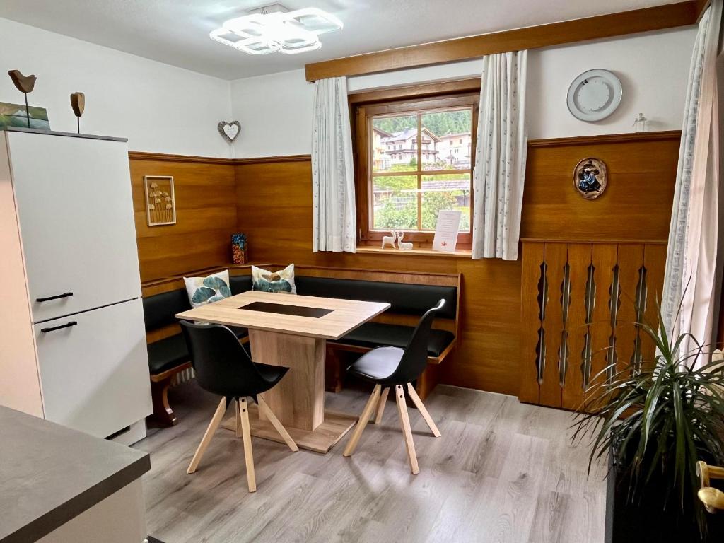 een keuken met een tafel en stoelen en een raam bij Maple Appartement in Mayrhofen