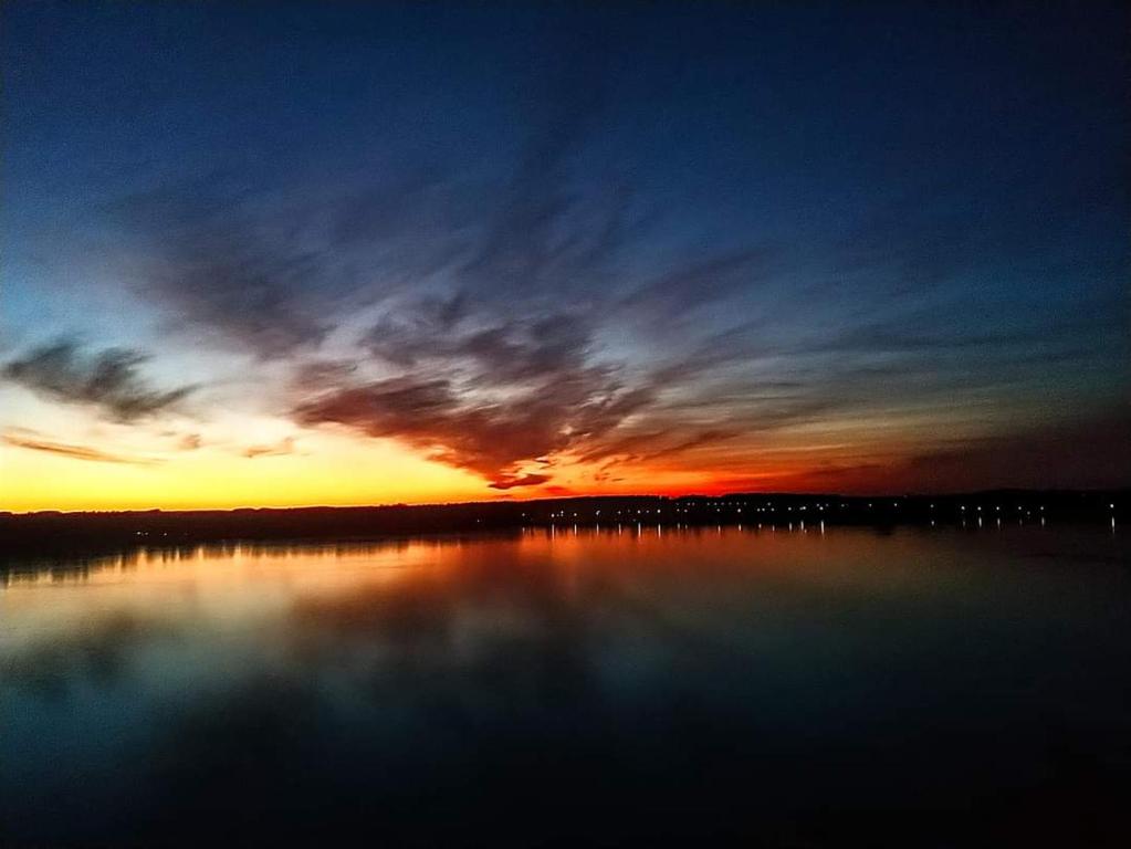 a sunset over a large body of water at MIA N 37 Apartament Ełk in Ełk