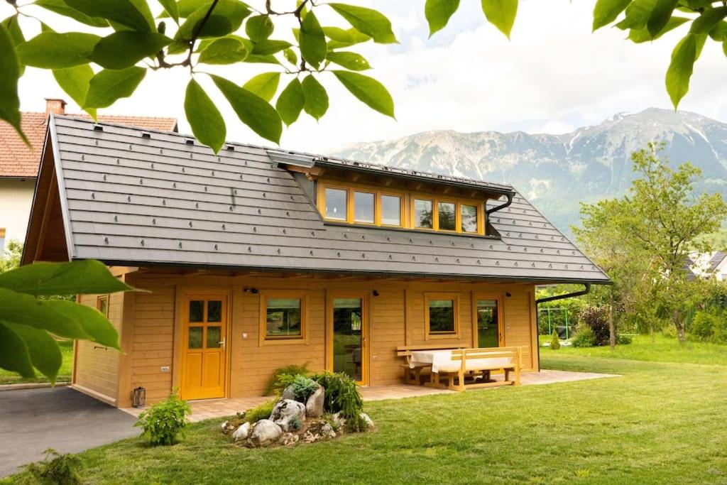 uma pequena casa com um banco à frente em A Nest Under the Karawanks em Žirovnica