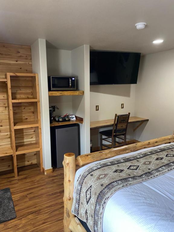 um quarto com uma cama e uma secretária com um micro-ondas em Summit Lake Lodge em Summit Lake