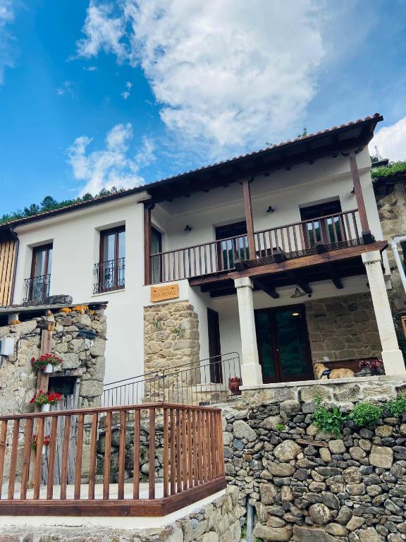 a large white house with a stone wall at Casa Aturuxo in Belesar