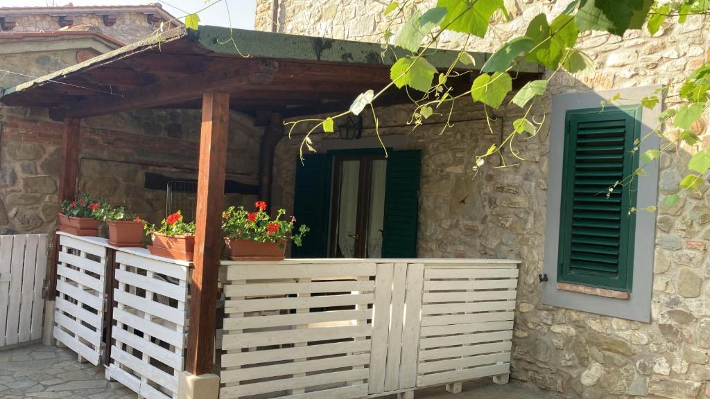 une maison avec une clôture blanche et quelques plantes dans l'établissement Da Valentino e Manuela, à Barberino di Mugello