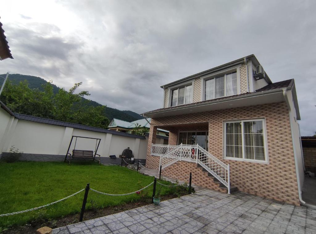 a brick house with a staircase in a yard at Voyage Gabala in Gabala