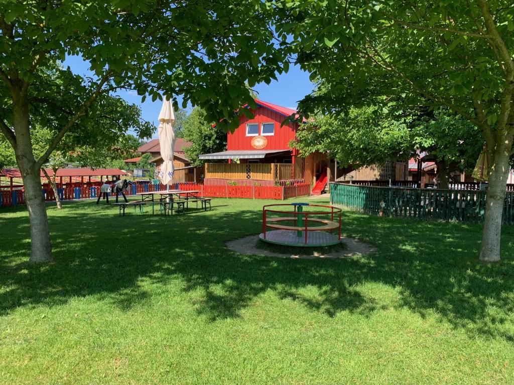un parque con mesas de picnic y un edificio rojo en Ferienhaus Spielburg, en Altötting
