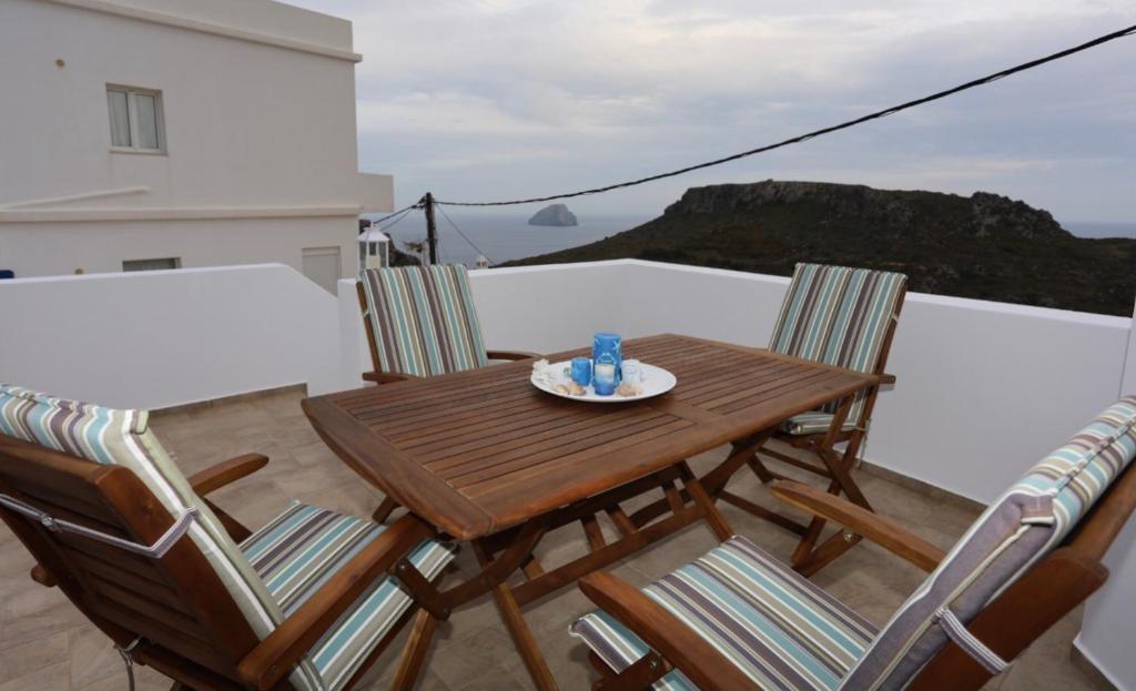 a wooden table and chairs on a balcony at Hytra view house in Kythira