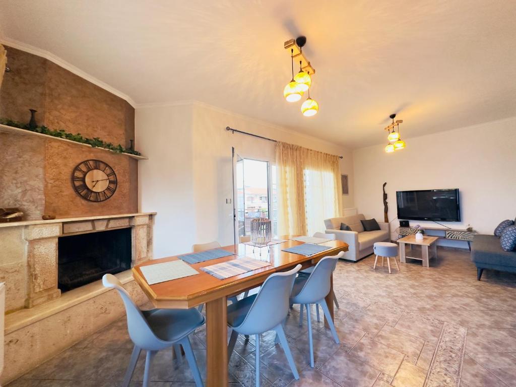 a living room with a wooden table and chairs at Almyriki Apartment in Ierissos
