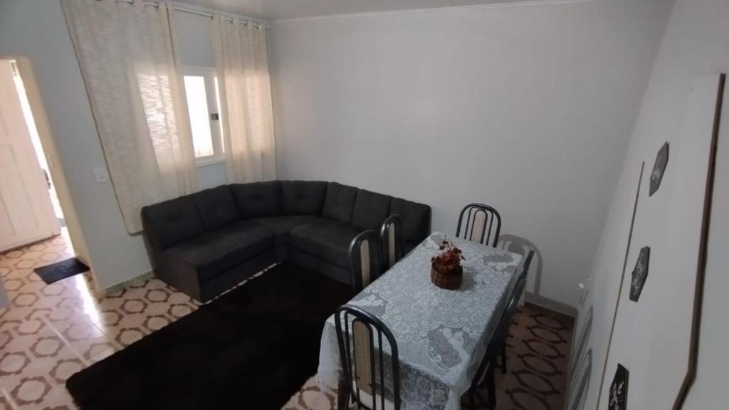 ein Wohnzimmer mit Sofa und Tisch in der Unterkunft CASA DU VÔ - Cantinho Du Vô in Santa Teresa