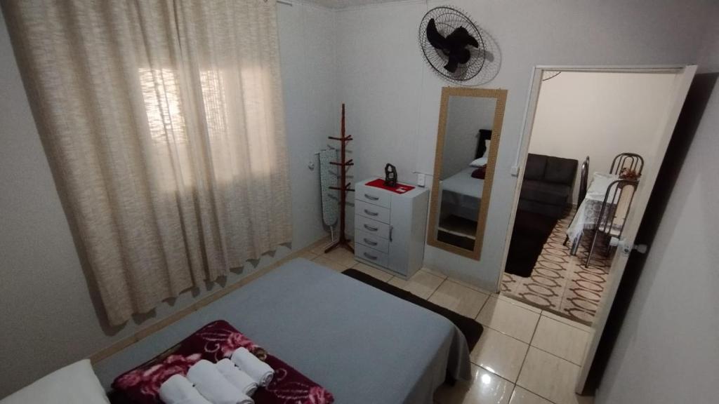 Dormitorio pequeño con cama y espejo en CASA DU VÔ, en Santa Teresa