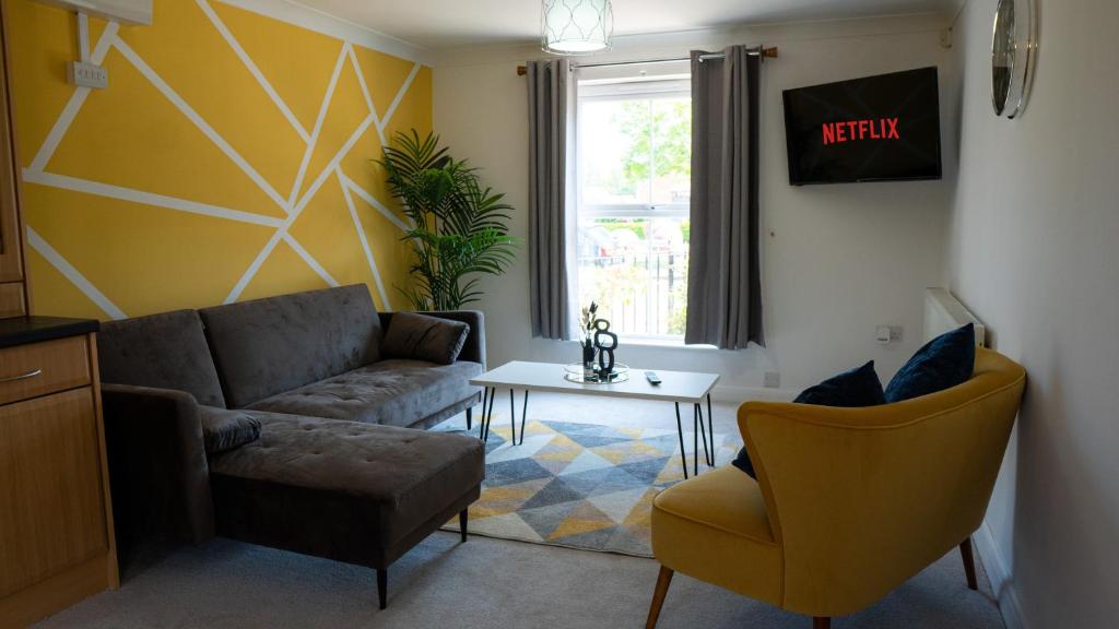 a living room with a couch and a table at Modern Marvel in Whaddon