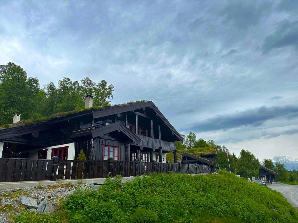 a house on top of a hill with a fence at Roalden Mountain Lodge in Stranda