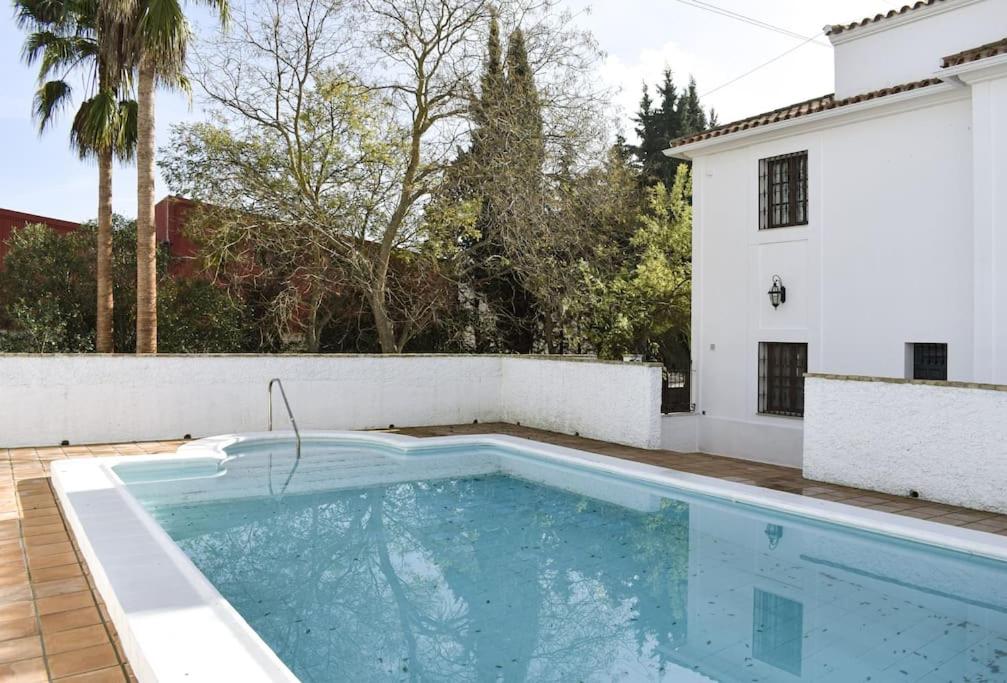 una piscina frente a una casa blanca en Villa Tela & Vino, en Montilla