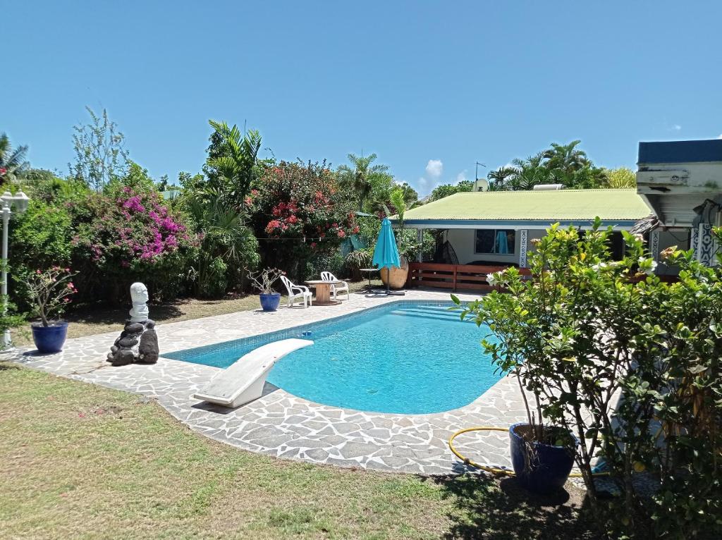 a swimming pool in the backyard of a house at Maison de vacances avec piscine et accès plage de sable blanc in Punaauia