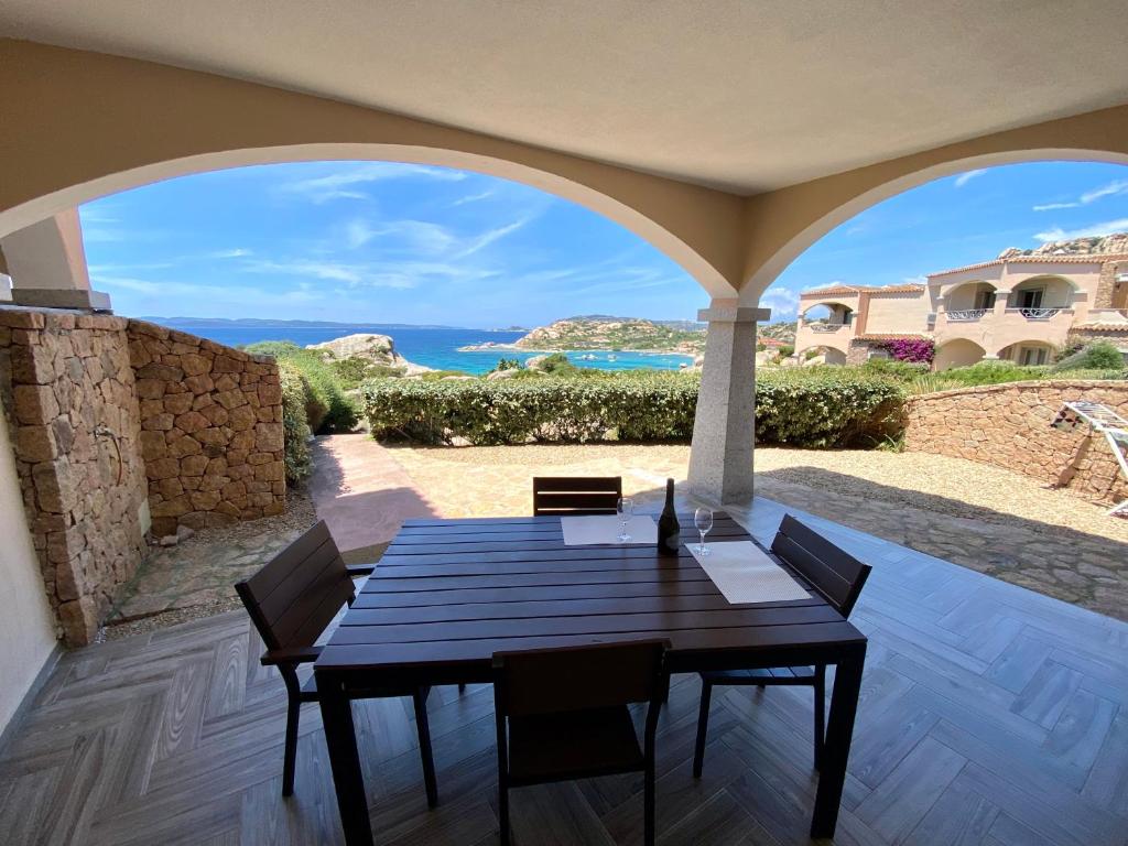 a table and chairs on a patio with a view of the ocean at A Punta Tegge il mare la spiaggia il tramonto in La Maddalena