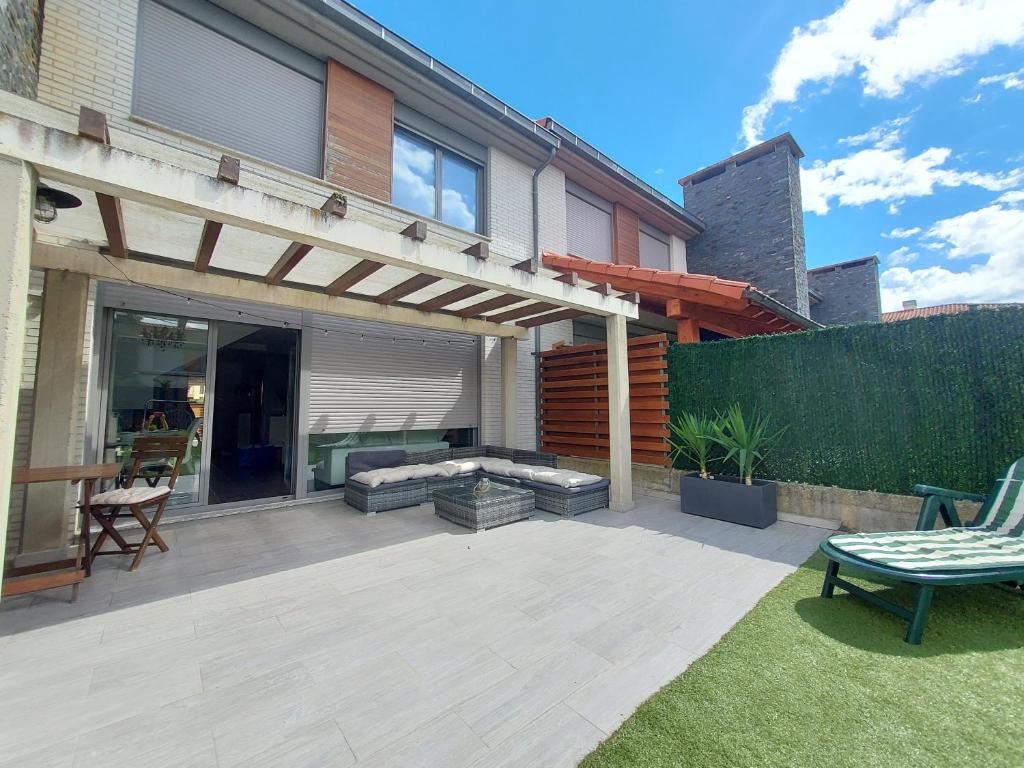 a backyard with a patio with a couch and a pergola at Adosado en Cirueña con Chimenea in Cirueña