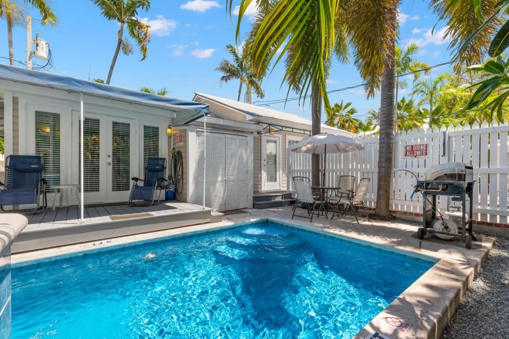 uma piscina com casa e palmeiras em Poolside Paradise by Brightwild em Key West
