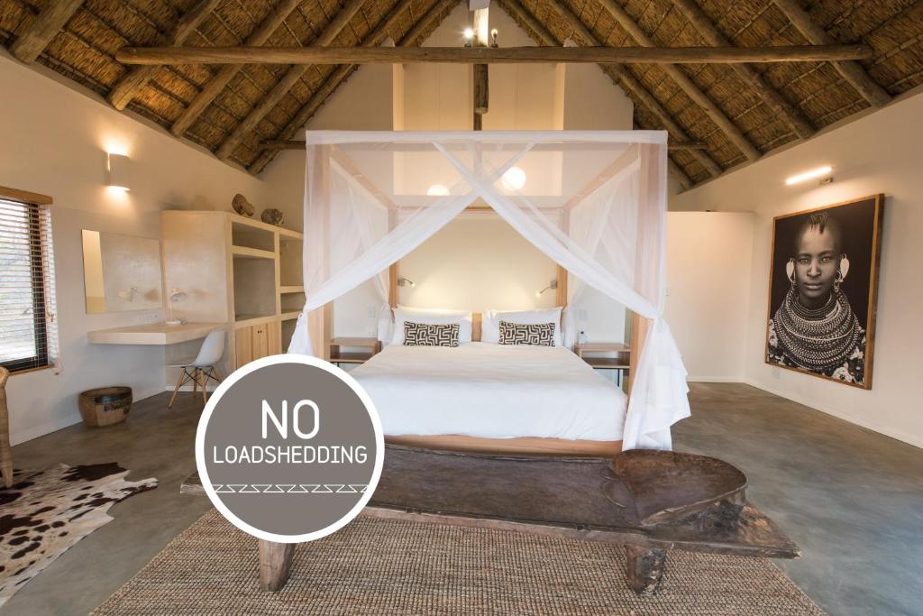 1 dormitorio con 1 cama con dosel en Unembeza Boutique Lodge & Spa en Hoedspruit