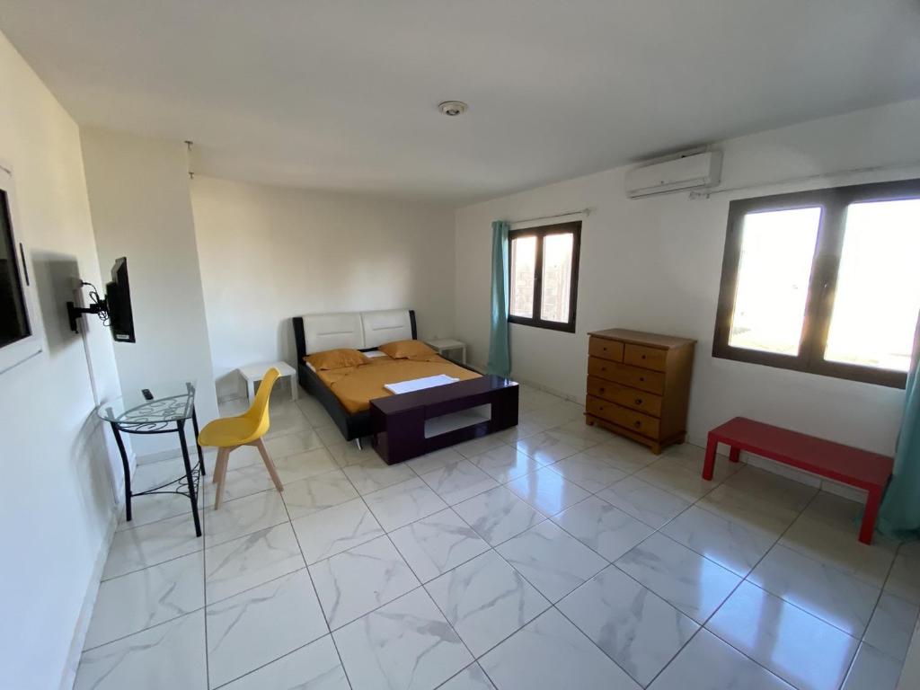 um quarto com uma cama, uma mesa e uma cadeira em Résidences Gamly em Mamoudzou