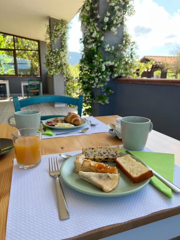 un tavolo con un piatto di pane tostato, caffè e succo d'arancia di Agriturismo Graziano e Barbara a Porto Conte