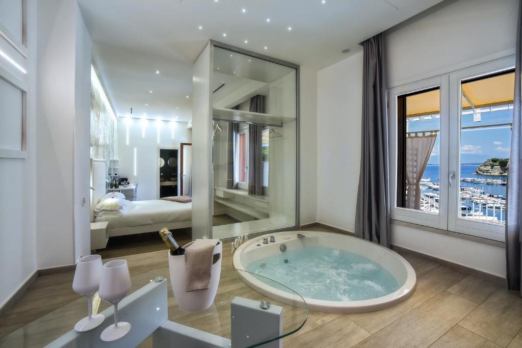 a bathroom with a large tub and a bedroom at La Sciabica in Agropoli