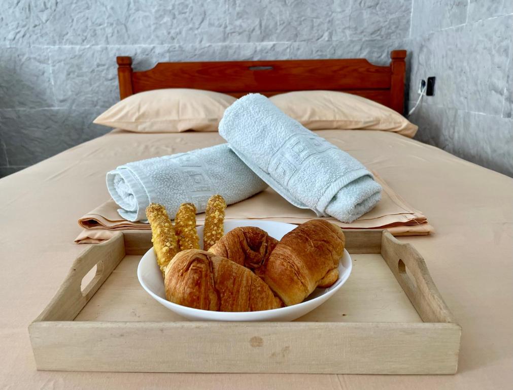 ein Tablett mit einer Schüssel Brot und Mais auf einem Bett in der Unterkunft Poseidonia's Breeze in Posidhonía