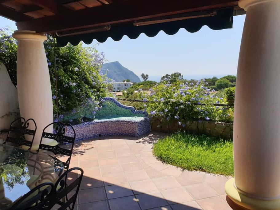 eine Terrasse mit Stühlen und Gartenblick in der Unterkunft CASA VACANZE 'LA BOUGANVILLEA' FORIO ISCHIA in Ischia