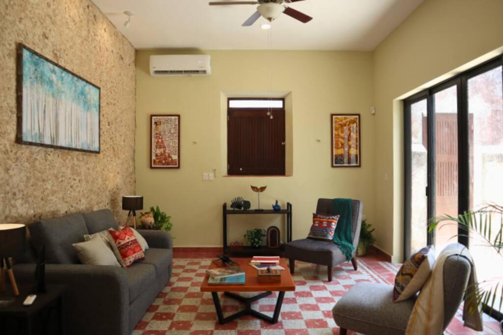 uma sala de estar com um sofá e uma mesa em Casa Coco em Mérida