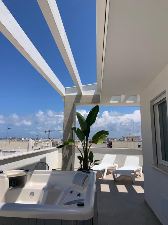 balcón con fregadero y sillas en la azotea en BLUETTE SUITE & BOAT, en Polignano a Mare