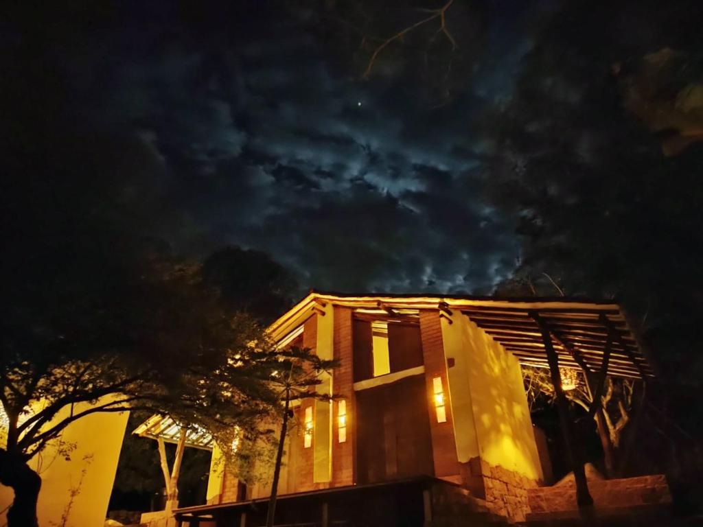 una casa con sus luces encendidas por la noche en Estancia Arboreto - Reserva Natural, en Barichara