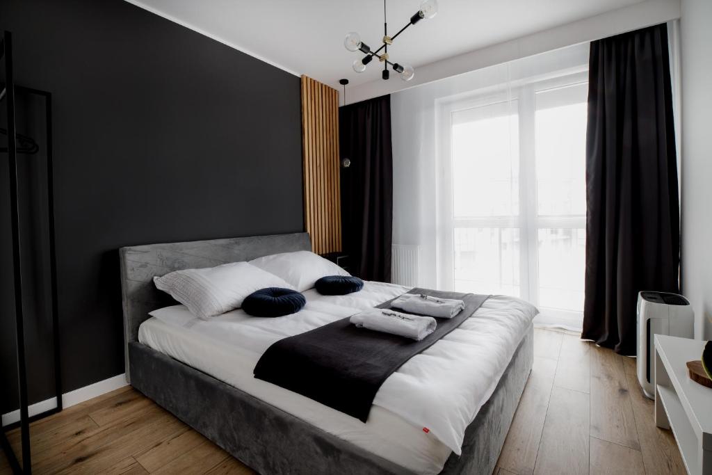 1 dormitorio con 1 cama grande y 2 almohadas en Apartament Aura, en Biała Podlaska