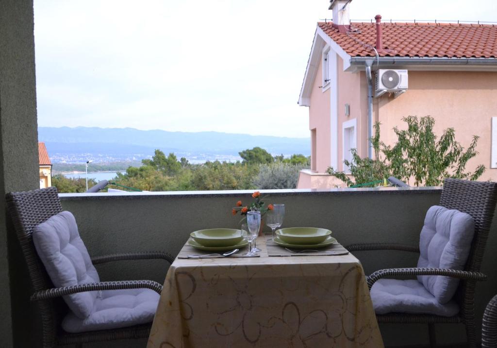 einen Tisch mit zwei Schüsseln auf dem Balkon in der Unterkunft Apartment Malči in Čižići
