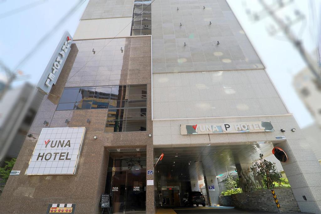 a building with a hotel sign in front of it at HOTEL YUNA Business in Busan