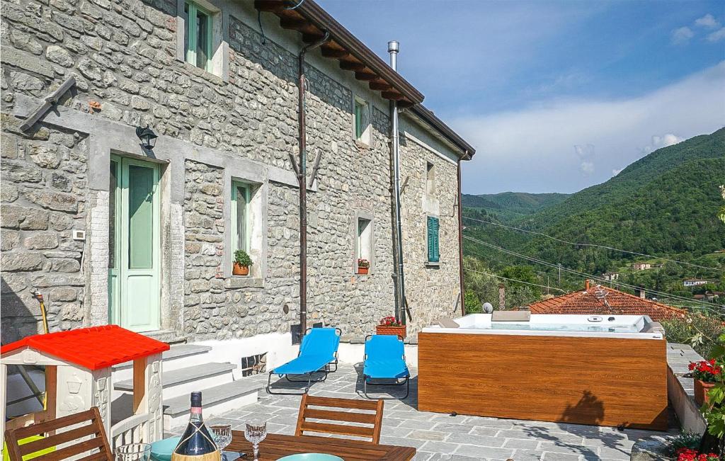 a stone house with chairs and a hot tub on a patio at C Tonino in Pugliano