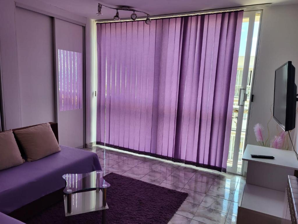 um quarto roxo com uma cama e uma grande janela em Apartment Stefani em Rijeka