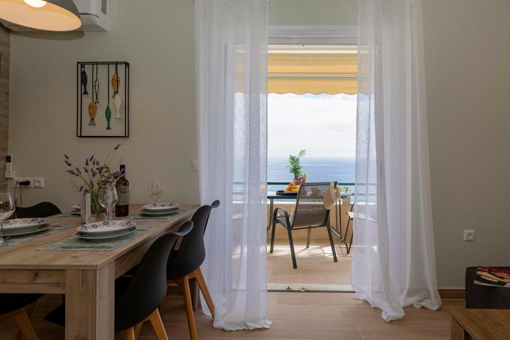 a dining room with a table and a view of the ocean at sofia's apart 4u (114) in Glyfada